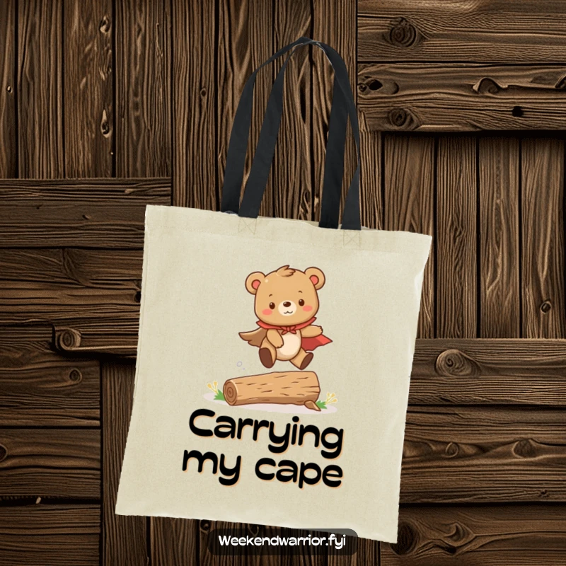 Funny tote bag featuring a cute bear cub wearing a cape, captured mid-leap over a small log, embodying adventure.
